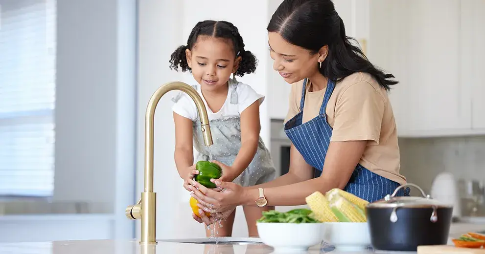 Madre e hija lavando verduras