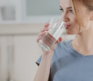 Mujer bebiendo agua en un vaso